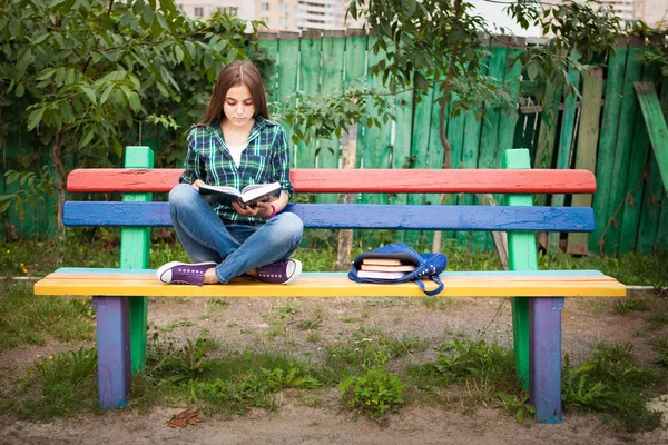 Красива дівчина-підліток читає книгу на відкритому повітрі — стокове фото
