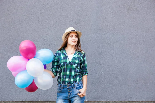 Felice adolescente con palloncini vicino muro grigio con spazio copia — Foto Stock