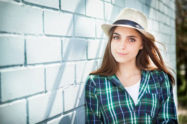 Piękne nastoletnie dziewczyny w kapelusz w pobliżu niebieską ścianą — Zdjęcie stockowe