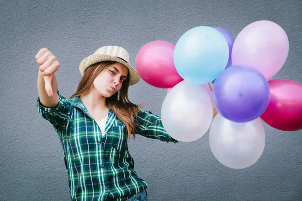 Beautiful girl with balloons show thumbs down — Stock Photo, Image