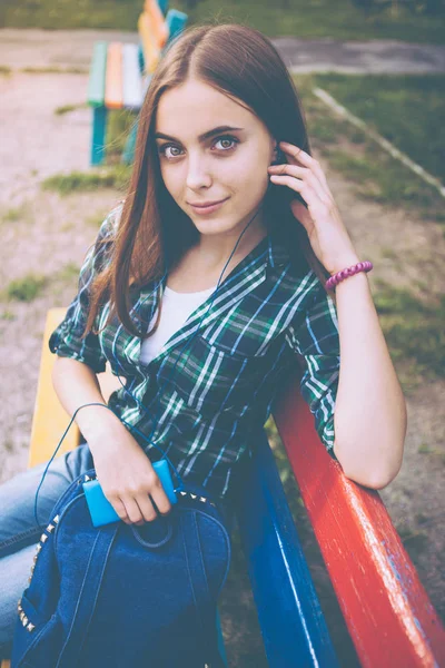 Девушка слушает музыку в наушниках на улице — стоковое фото