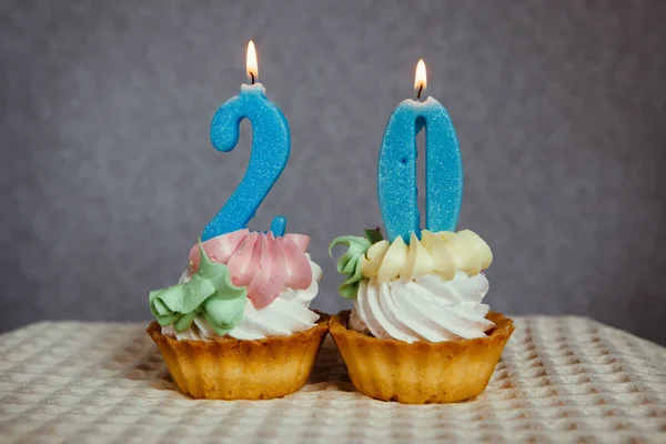 Cumpleaños aniversario 20 años con cupcakes y velas números azules — Foto de Stock