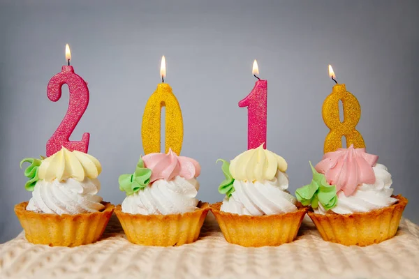 Feliz año nuevo 2018, velas doradas y rosadas en cupcakes — Foto de Stock