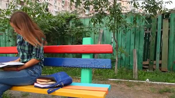 Mujer joven leyendo libro al aire libre — Vídeos de Stock