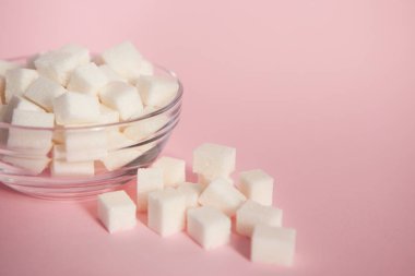 Pembe bir arka plan üzerinde cam kase küp şeker