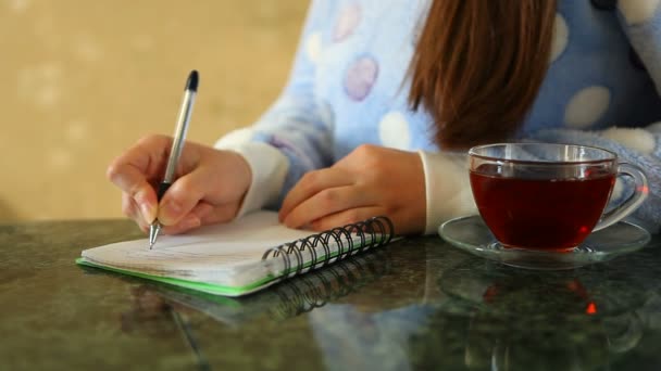 Mujer Escribiendo Diario Con Una Taza Sobre Mesa — Vídeo de stock