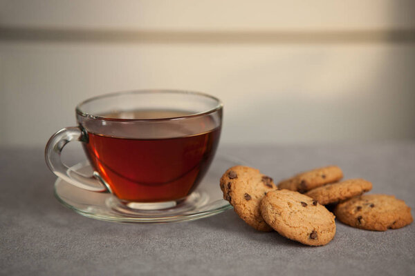 Cup of black tea and Chocolate chip cookies on the gray table