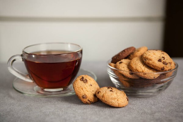 Glass cup of black tea and Chocolate chip cookies on the table