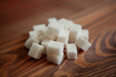 Kahverengi ahşap masa üzerinde kesme beyaz şeker