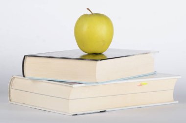İki kapalı kitap üstünde yeşil elma