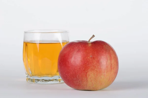 Czerwone jabłko do przodu do szkła z sokiem jabłkowym na białym tła — Zdjęcie stockowe