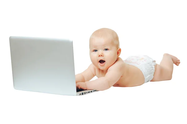 El niño se sienta delante de una computadora portátil y presiona los botones — Foto de Stock