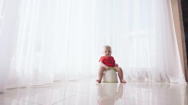 Bambino piccolo si siede sul vasino e si allevia — Video Stock