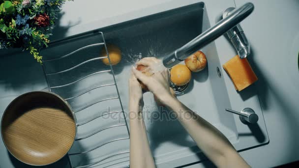 Früchte unter fließendem Wasser in der Spüle waschen — Stockvideo