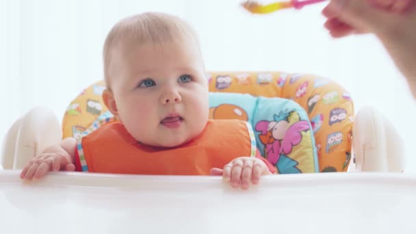 Un niño hambriento requiere comida y come codiciosamente de una cuchara — Vídeos de Stock