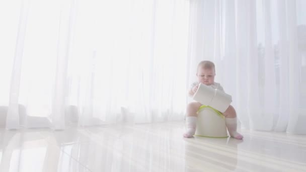 Маленький ребенок сидит на горшке и освобождается — стоковое видео