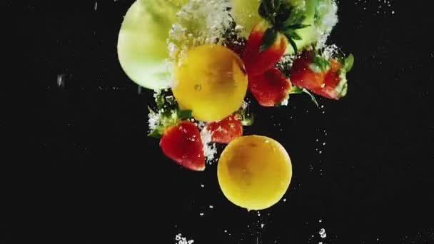 Beaucoup d'oranges, pommes, fraises tombant dans l'eau au ralenti — Video