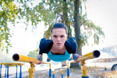Athletic woman training on parallel bars clipart