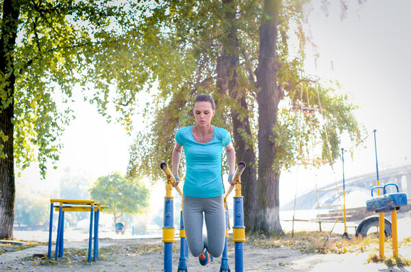 Woman working out on parallel bars 