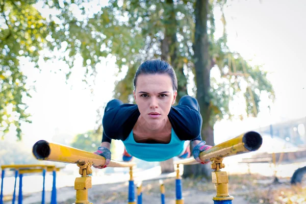 Спортивные женщины тренируются на параллельных брусьях — стоковое фото