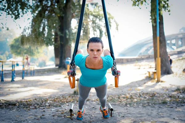 Mulher trabalhando com equipamentos esportivos — Fotografia de Stock