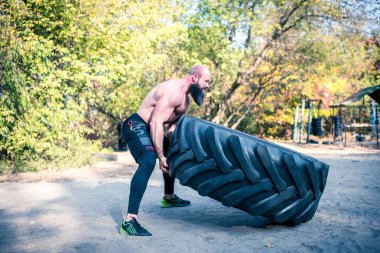 Strong man working out with tractor tire clipart
