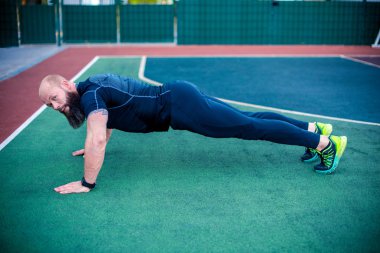 Muscular man doing plank position  clipart