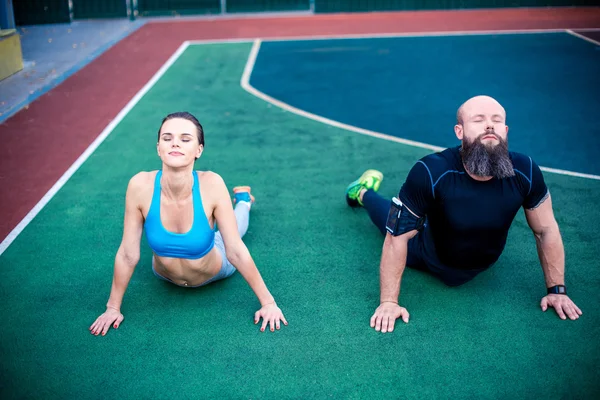 Atletische vrienden stretching na een training — Stockfoto