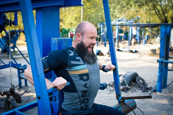 Entrenamiento del hombre en equipo de prensa de pecho — Foto de Stock