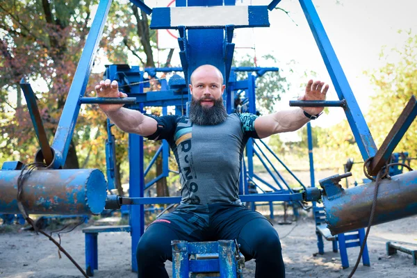 Entrenamiento del hombre en equipo de prensa de pecho —  Fotos de Stock