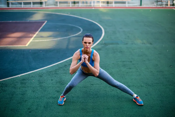 Frau macht Übungen im Stadion — Stockfoto