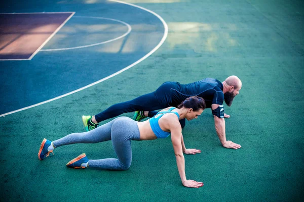 Muscular couple doing plank position — Stock Photo, Image