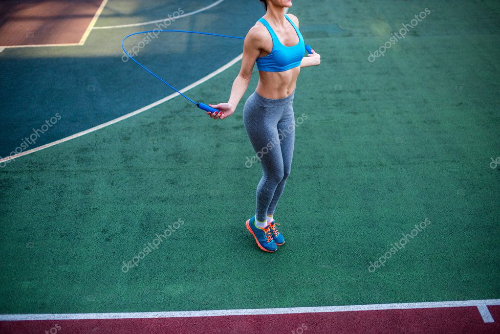 Athletic woman using jump rope — Stock Photo © AntonShevchenko 126079914