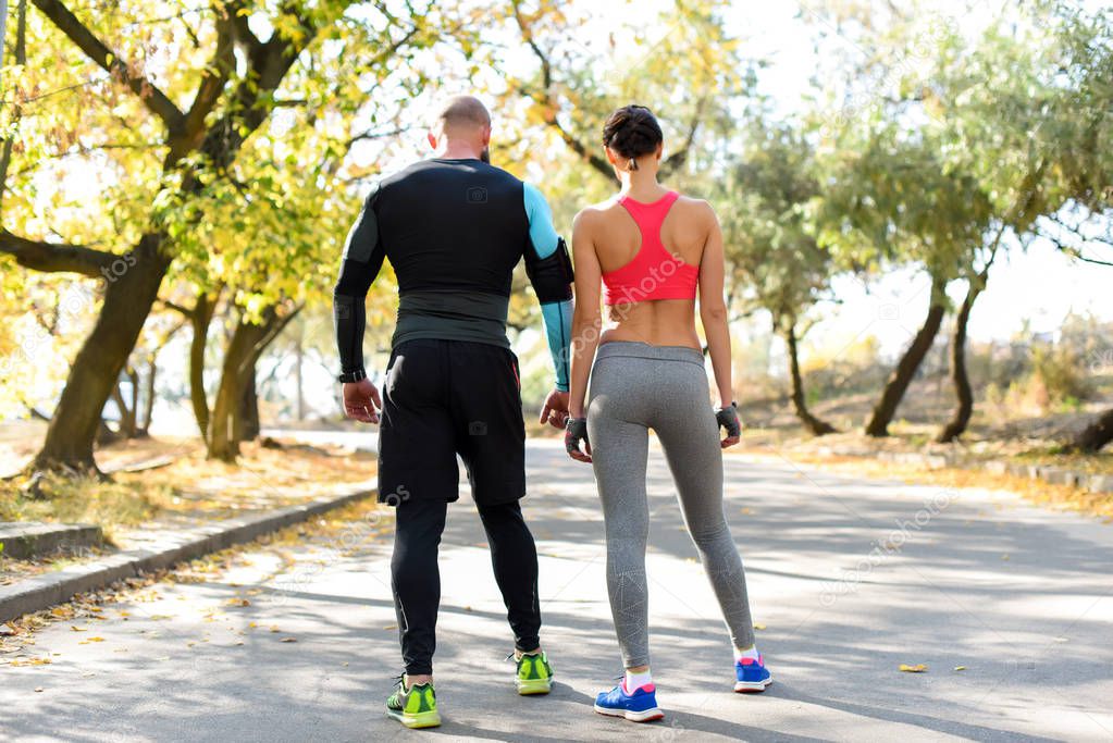 sportive couple standing on road 