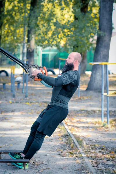 Мужчина в спортивной одежде тренируется в парке — стоковое фото