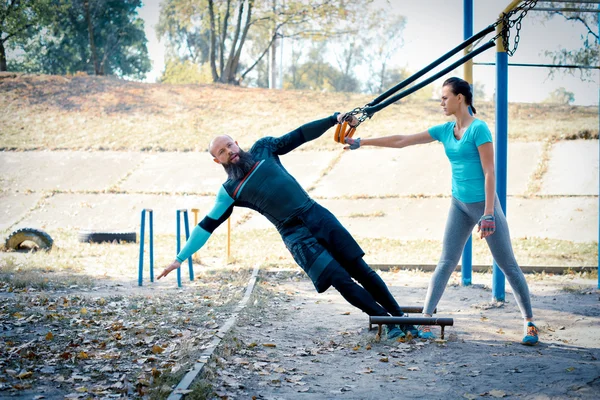 Pareja en ropa deportiva haciendo ejercicio juntos - foto de stock