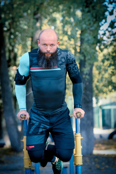 Homme travaillant sur des barres parallèles — Photo de stock