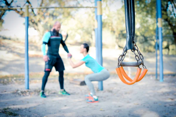 Casal trabalhando com equipamentos esportivos em primeiro plano — Fotografia de Stock