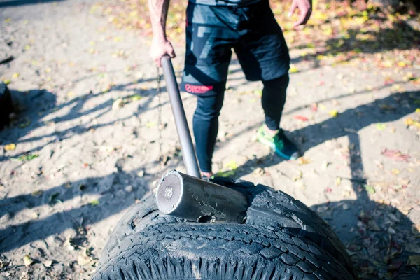 Mann übt mit Hammer und Reifen — Stockfoto