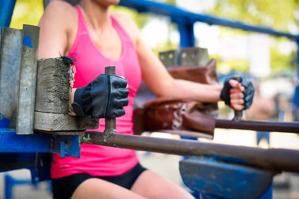 Frau trainiert an Sportgeräten — Stockfoto