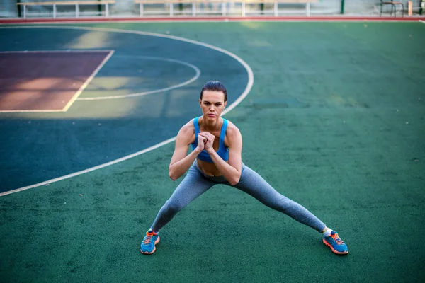 Женщина делает упражнения на стадионе — стоковое фото