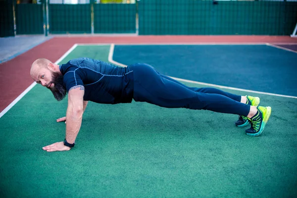 Hombre musculoso haciendo posición de tablón - foto de stock