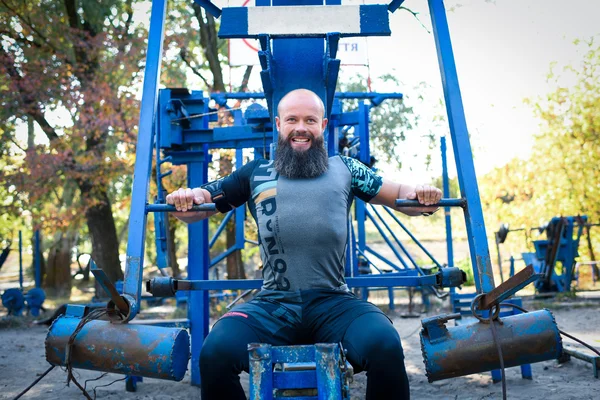 Bearded man doing exercises for chest — Stock Photo