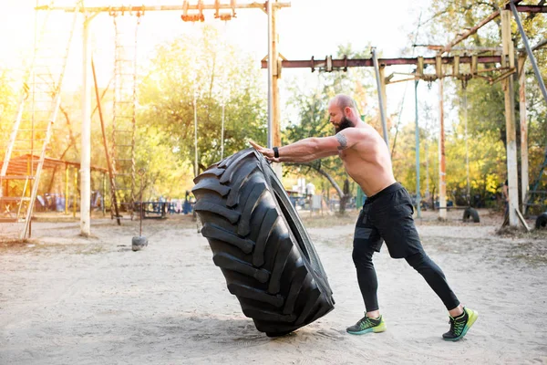 Deportista haciendo ejercicio con neumático - foto de stock