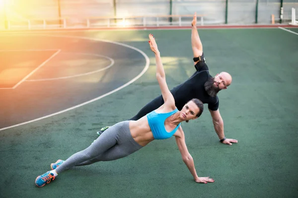 Couple exercising on stadium — Stock Photo