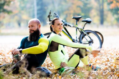cyclists sitting and resting near bicycles