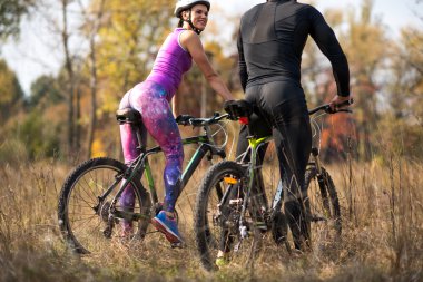 Cyclists in autumn park clipart