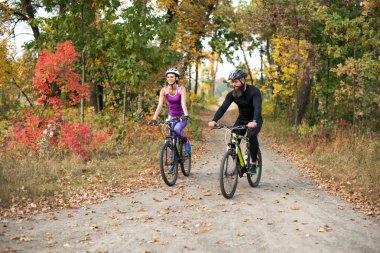 people cycling in autumn park clipart