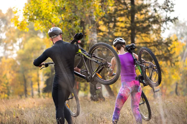 Ciclistas que llevan sus bicicletas — Foto de Stock