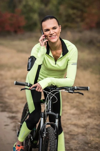 Girl cyclist talking on phone — Free Stock Photo